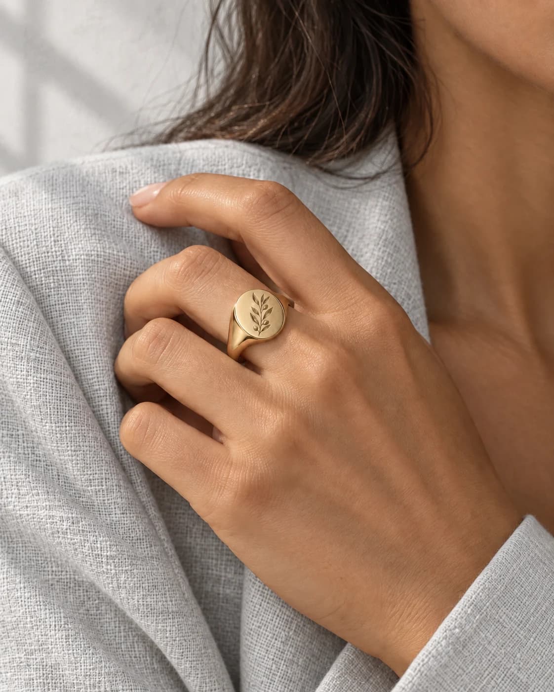 Olive-branch signet worn on a hand — AI styling preview