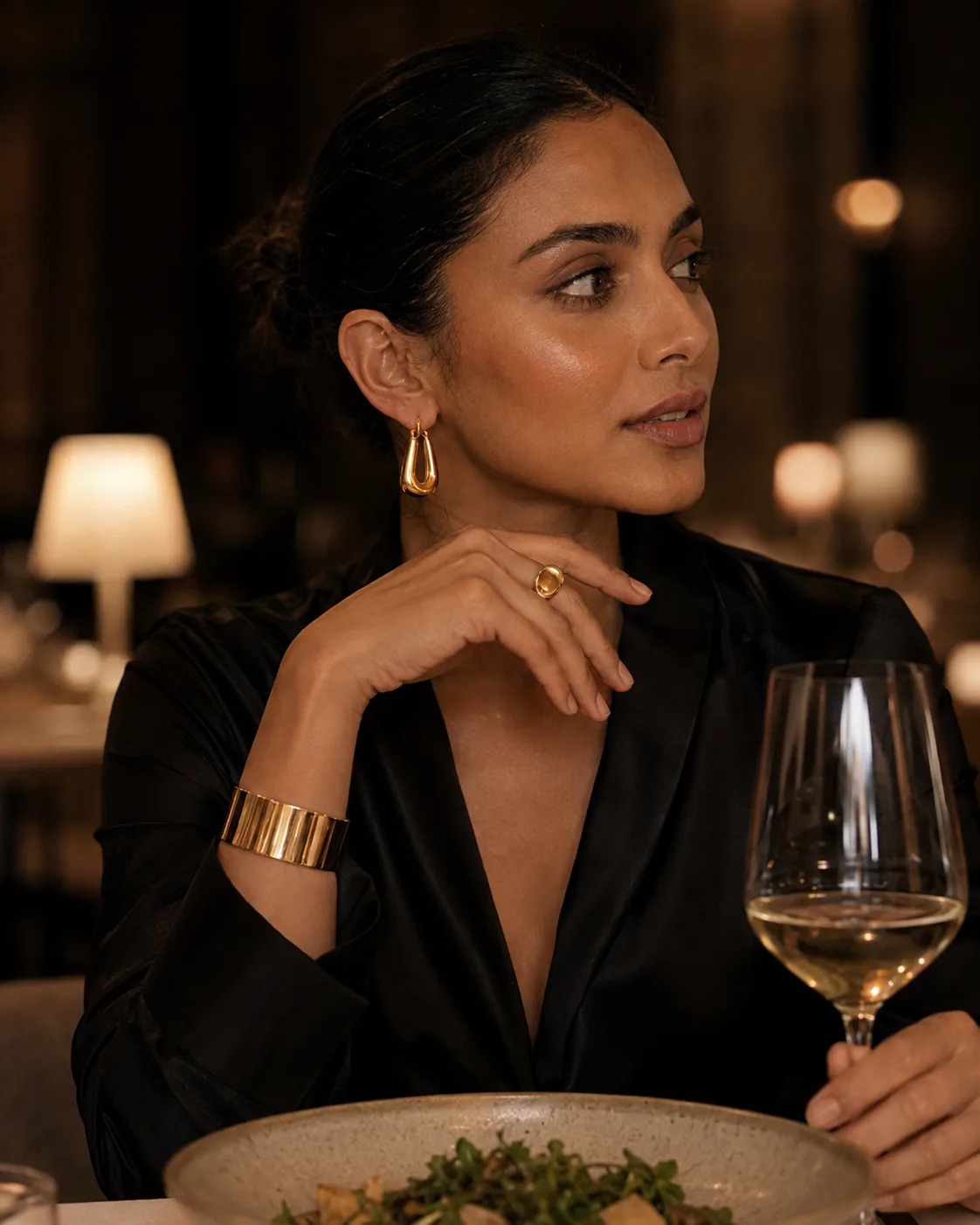 The same drop earrings and cuff with the ring added, at a restaurant table